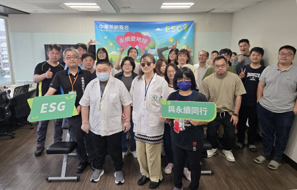 Group of staff posing in an office with an ESG banner, holding a green 'ESG' sign and a Chinese text sign in front.