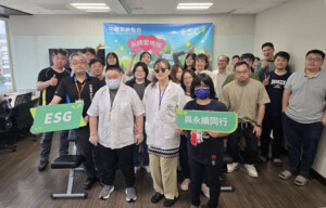 Group of staff posing in an office with an ESG banner, holding a green 'ESG' sign and a Chinese text sign in front.